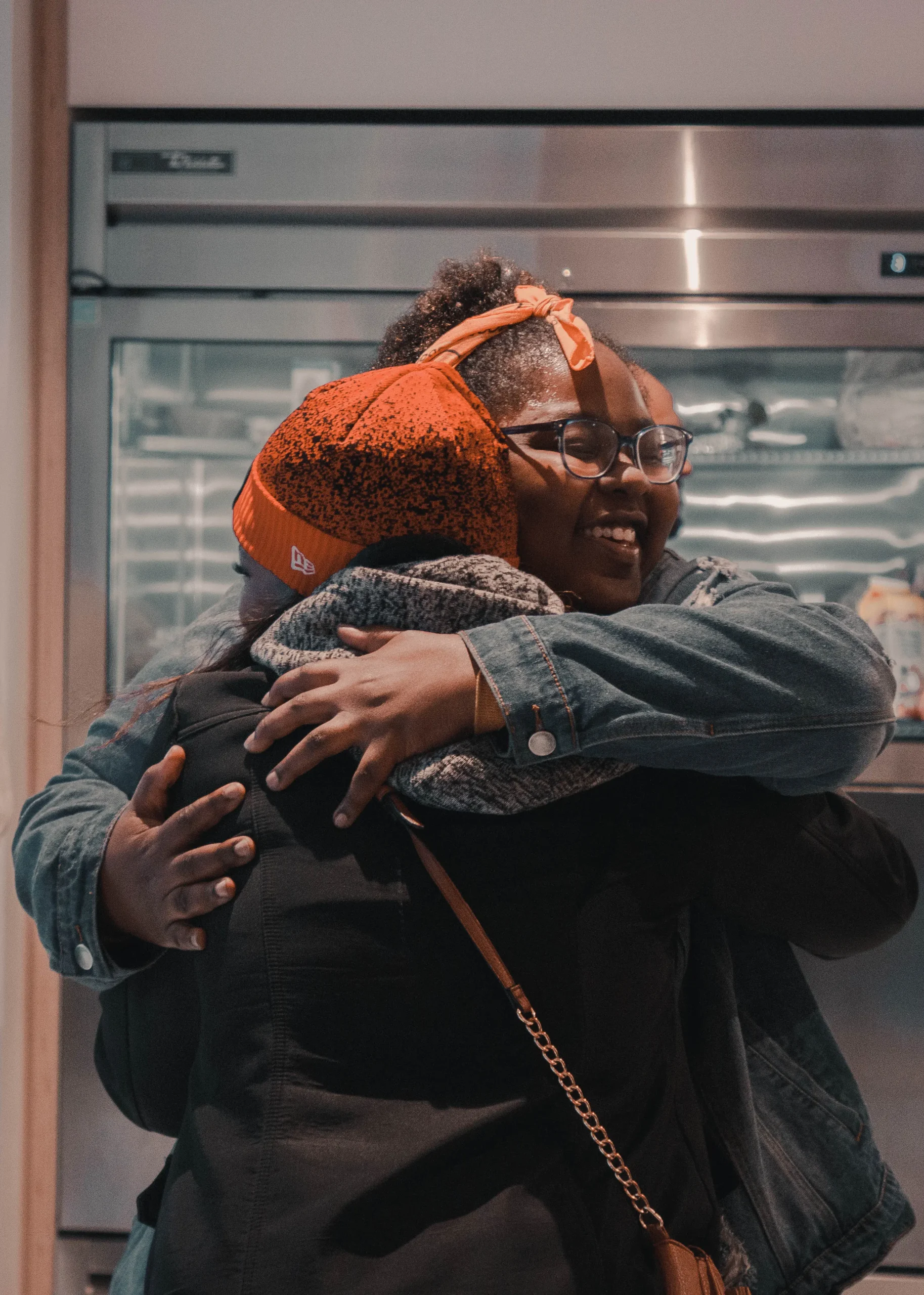 Two re:WORK community members greeting one another with a hug.